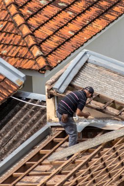 Marilia, Sao Paulo, Brezilya, 29 Ağustos 2023. Mailia şehir merkezindeki ticari bir noktanın çatısını yenilemek için bir evin fayanslarını söken bir işçinin üst görüntüsü