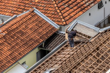 Marilia, Sao Paulo, Brezilya, 29 Ağustos 2023. Mailia şehir merkezindeki ticari bir noktanın çatısını yenilemek için bir evin fayanslarını söken bir işçinin üst görüntüsü