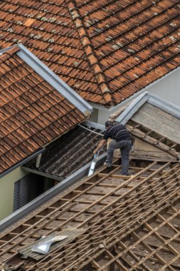 Marilia, Sao Paulo, Brezilya, 29 Ağustos 2023. Mailia şehir merkezindeki ticari bir noktanın çatısını yenilemek için bir evin fayanslarını söken bir işçinin üst görüntüsü