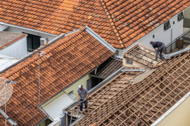 Marilia, Sao Paulo, Brezilya, 29 Ağustos 2023. Marilia şehir merkezindeki ticari bir noktanın çatısını yenilemek için bir evin fayanslarını söken bir işçinin üst görüntüsü