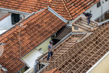 Marilia, Sao Paulo, Brezilya, 29 Ağustos 2023. Marilia şehir merkezindeki ticari bir noktanın çatısını yenilemek için bir evin fayanslarını söken bir işçinin üst görüntüsü