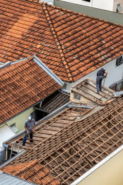 Marilia, Sao Paulo, Brezilya, 29 Ağustos 2023. Marilia şehir merkezindeki ticari bir noktanın çatısını yenilemek için bir evin fayanslarını söken bir işçinin üst görüntüsü