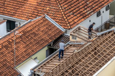 Marilia, Sao Paulo, Brezilya, 29 Ağustos 2023. Marilia şehir merkezindeki ticari bir noktanın çatısını yenilemek için bir evin fayanslarını söken bir işçinin üst görüntüsü