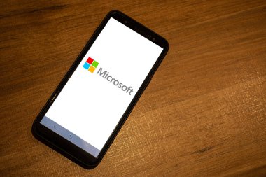 Sao Paulo, Brezilya, Mayıs 05, 2024. Microsoft logosu Brezilya 'da ahşap masa arkaplanlı bir akıllı telefonda görülüyor