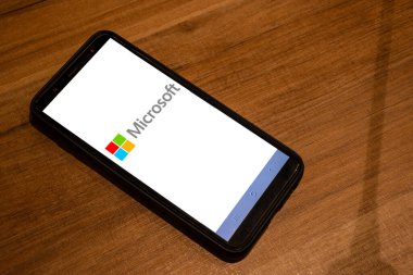 Sao Paulo, Brezilya, Mayıs 05, 2024. Microsoft logosu Brezilya 'da ahşap masa arkaplanlı bir akıllı telefonda görülüyor