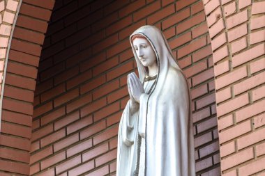 Ftima Anıtı, Katolik dininde Tanrı 'nın annesi, Fatima' nın Hanımı, Brezilya 'da tuğla bir duvarın arka planında Bakire Meryem' in heykeli.