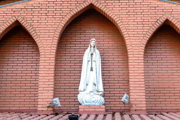 stock image Statue of the image of Our Lady of Fatima, mother of God in the Catholic religion, Our Lady of the Rosary of Ftima, Virgin Mary with the background of a brick wall in Brazil