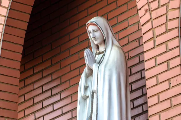 stock image Statue of the image of Our Lady of Ftima, mother of God in the Catholic religion, Our Lady of the Rosary of Fatima, Virgin Mary with the background of a brick wall in Brazil
