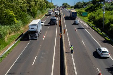 Marilia, SP, Brezilya, 12 Mart 2024. İnşaat işçileri, insanların Brezilya 'daki bir otoyolun betondan geçmesini engellemek için bariyerler kuruyor. Bu çarpışmaları azaltacaktır..