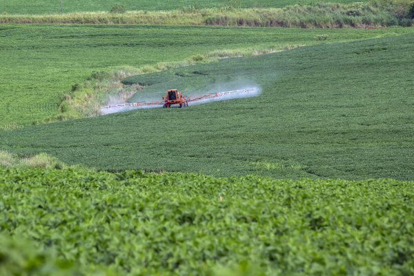 Тракторные удобрения или пестициды на соевом поле с опрыскивателем в Бразилии