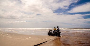 Ilha Comprida, Sao Paulo, Brezilya, 12 Mart 2015. Turistler Sao Paulo eyaletinde, Ilha Comprida 'da Boqueirao Sul plajı boyunca bisikletle geziyorlar.