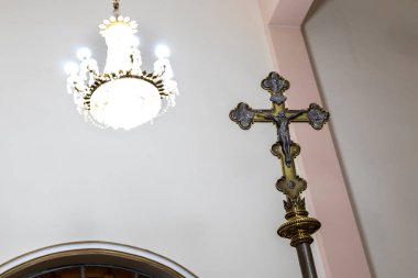 Kilisenin içinde ayinde kullanılan Katolik haçı ve Brezilya 'da arka planda lambalar olan bir avize.