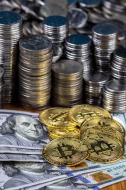 100 dolarlık banknotların üzerindeki altın bitcoin kripto para birimlerini kapatın. Bitcoin, gümüş sikkeler ve nakit fon