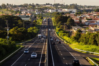 Marilia, Sao Paulo, Brezilya, 13 Mart 2023. Marilia, SP 'den geçen Contorno otoyolunda araçlar hareket ediyor. Arka planda Marilia alışveriş merkezini görebilirsiniz.