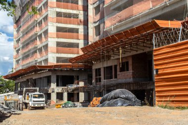 Marilia, Sao Paulo, Brezilya, 14 Mart 2024. Marilia, SP 'deki bir iskan binasının inşaat sahasında duran moloz yığınlarını toplayan kamyon.