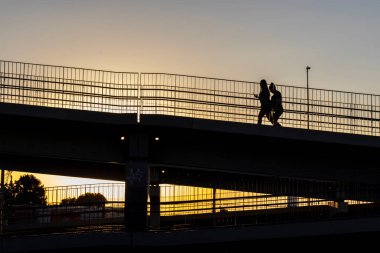 Marilia, Sao Paulo, Brezilya, 21 Nisan 2024. Marilia şehrinde otoyoldan geçen iki kadının silueti.