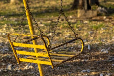 Brezilya 'da halk meydanındaki bir çocuk için salıncakta sallanan paslı demir sandalye.