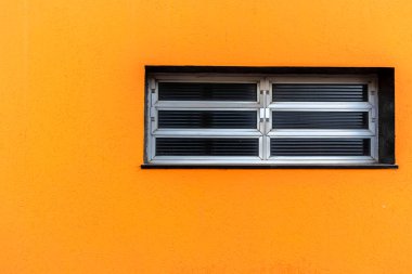 Brezilya 'da turuncu bir duvarda modern alüminyum eğimli pencere