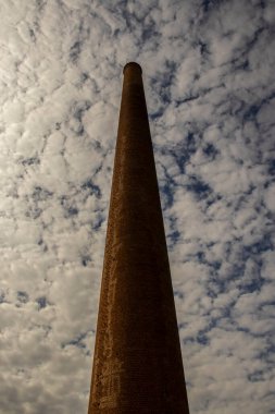 Eski bir tekstil fabrikasına ait tuğlalarla yapılmış bir baca. Arka planda Brezilya 'da bulutlar var.