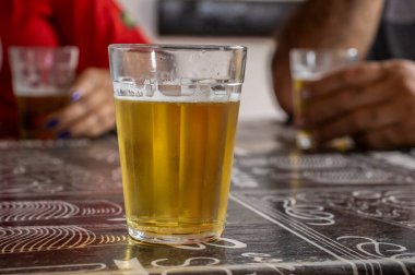 Brezilya 'da bir bar masasında bira ve köpük dolu bir bardak. Tipik işten sonra biralı Brezilya yemeği. Seçici odak