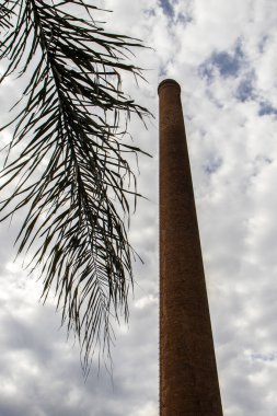 Tuğlalardan, kuru palmiye yapraklarından ve Brezilya 'da arka planda birçok bulutla inşa edilmiş bir baca.