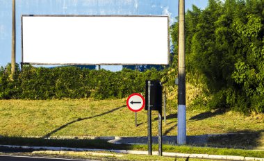 Brezilya kentsel bölgesinde solu gösteren trafik işaretli boş bir reklam panosu. Şehirlerde reklam, iletişim ve kamusal alan için görsel metafor.