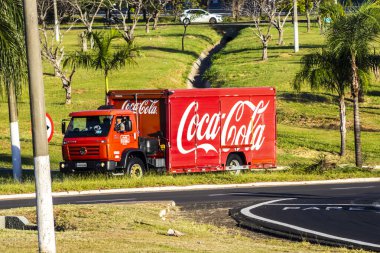 Marilia, Sao Paulo, Brezilya. 27 Şubat 2025. Coca-Cola FEMSA dağıtım kamyonu Marilia şehrinin yeşil bir kentindeki bir bulvardan geçiyor. Şehirlerdeki lojistik ve dağıtımı gösteriyor..