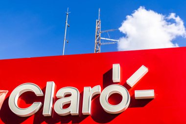 Marilia, Sao Paulo, Brezilya. 27 Mart 2025. Arka planda iletim antenleri olan Claro telekom imzası, parlak mavi gökyüzü altındaki bağlantıyı simgeliyor.