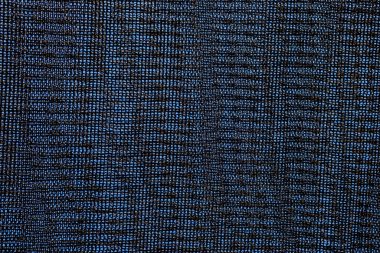 Mavi gökyüzüne karşı siyah gölgelendirme örgüsünün yakın çekimi. Genellikle tarımda güneş ışığından mahsulü korumak için kullanılır.