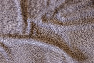 Gri, bej ve beyaz desenli kumaş yakın plan. Karmaşık dokuma deseni ve ince kıvrımlar zengin bir görsel etki yaratır.
