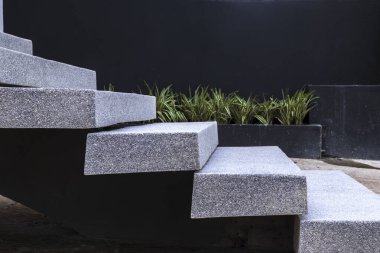 Açık havada modern granit merdivenlerin yakın çekimi, yeşil bitki örtüsüyle yan yana. Bu resim, taşın dayanıklılığını ve dokusunu vurgulayarak çağdaş mimari tasarımı iletir.