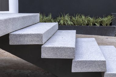 Açık havada modern granit merdivenlerin yakın çekimi, yeşil bitki örtüsüyle yan yana. Bu resim, taşın dayanıklılığını ve dokusunu vurgulayarak çağdaş mimari tasarımı iletir.