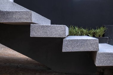 Açık havada modern granit merdivenlerin yakın çekimi, yeşil bitki örtüsüyle yan yana. Bu resim, taşın dayanıklılığını ve dokusunu vurgulayarak çağdaş mimari tasarımı iletir.