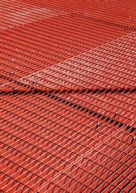Kırmızı metal şebeke, çapraz desen. Karışık çubuklar geometrik bir doku oluşturur. Mimari, endüstri veya soyut tasarım kavramları için uygundur.
