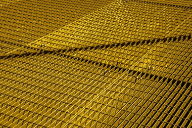 Altın metal şebeke, çapraz desen. Karışık çubuklar geometrik bir doku oluşturur. Mimari, endüstri veya soyut tasarım kavramları için uygundur.