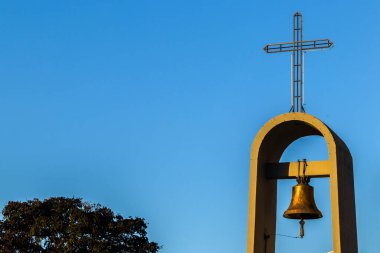 Brezilya 'da açık mavi gökyüzüne karşı kilise çan kulesi, üzerinde haç var. İnancın ve geleneğin sembolü.