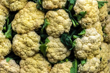 Close-up of fresh cauliflower showing its texture and color at a street market stall in Brazil. Ideal for healthy eating, agriculture, and culinary themes.