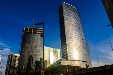 Sao Paulo, Brazil, July 28, 2024. Modern skyscrapers in Vila Olimpia, a major business district in Sao Paulo. The contrast of a building under construction next to a finished one in the city growth.