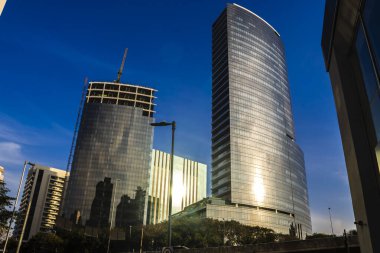 Sao Paulo, Brazil, July 28, 2024. Modern skyscrapers in Vila Olimpia, a major business district in Sao Paulo. The contrast of a building under construction next to a finished one in the city growth.
