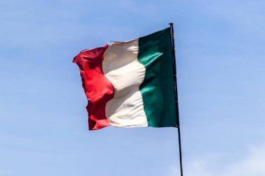 Açık mavi gökyüzünde sallanan İtalyan bayrağı. İtalya 'nın ulusal sembolü.