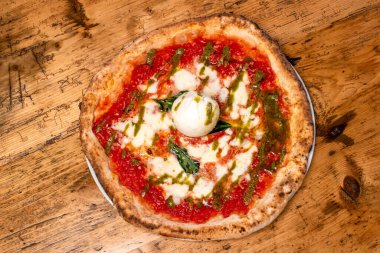 Taze İtalyan fesleğen ve peynirli pizzanın detayları.