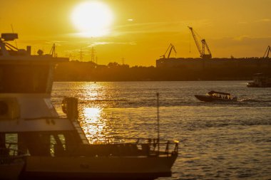 Romanya 'nın Tulcea kentinde, Delta yakınlarındaki Tuna Nehri' nde gün batımında tekneler