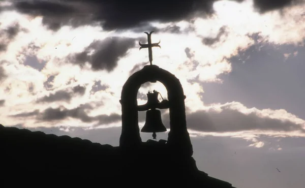 silhouette of a man with a cross on the background of the sunset