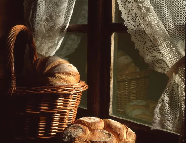 木のテーブルの上のバスケットにパンとパン — ストック写真