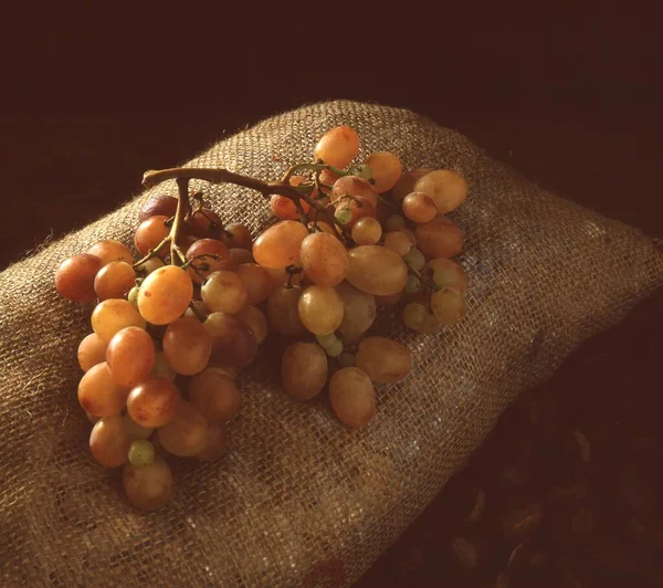 在木制背景上篮子里的葡萄 — 图库照片