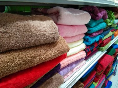 Bir ev geliştirme mağazasında çeşitli renkte havlu yığını