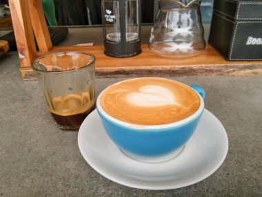 Ahşap sıcak cappucino bardak geçerli. Bir sanat latte üzerinde.