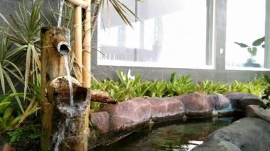 pond in the garden with a shower made of bamboo