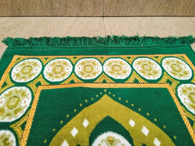 a green prayer rug for muslim prayer