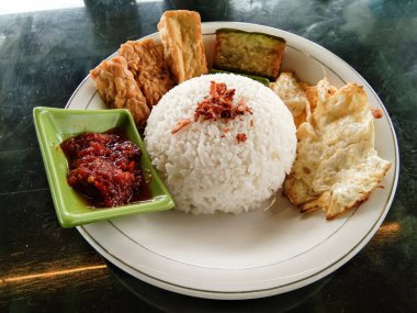 traditional menu called T4 which consists of rice, tofu, tempeh, eggs sunny side up, eggplant and sambal